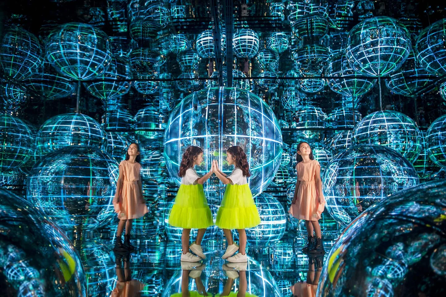 Visitors exploring luminous spheres and reflections at AYA Universe in Dubai