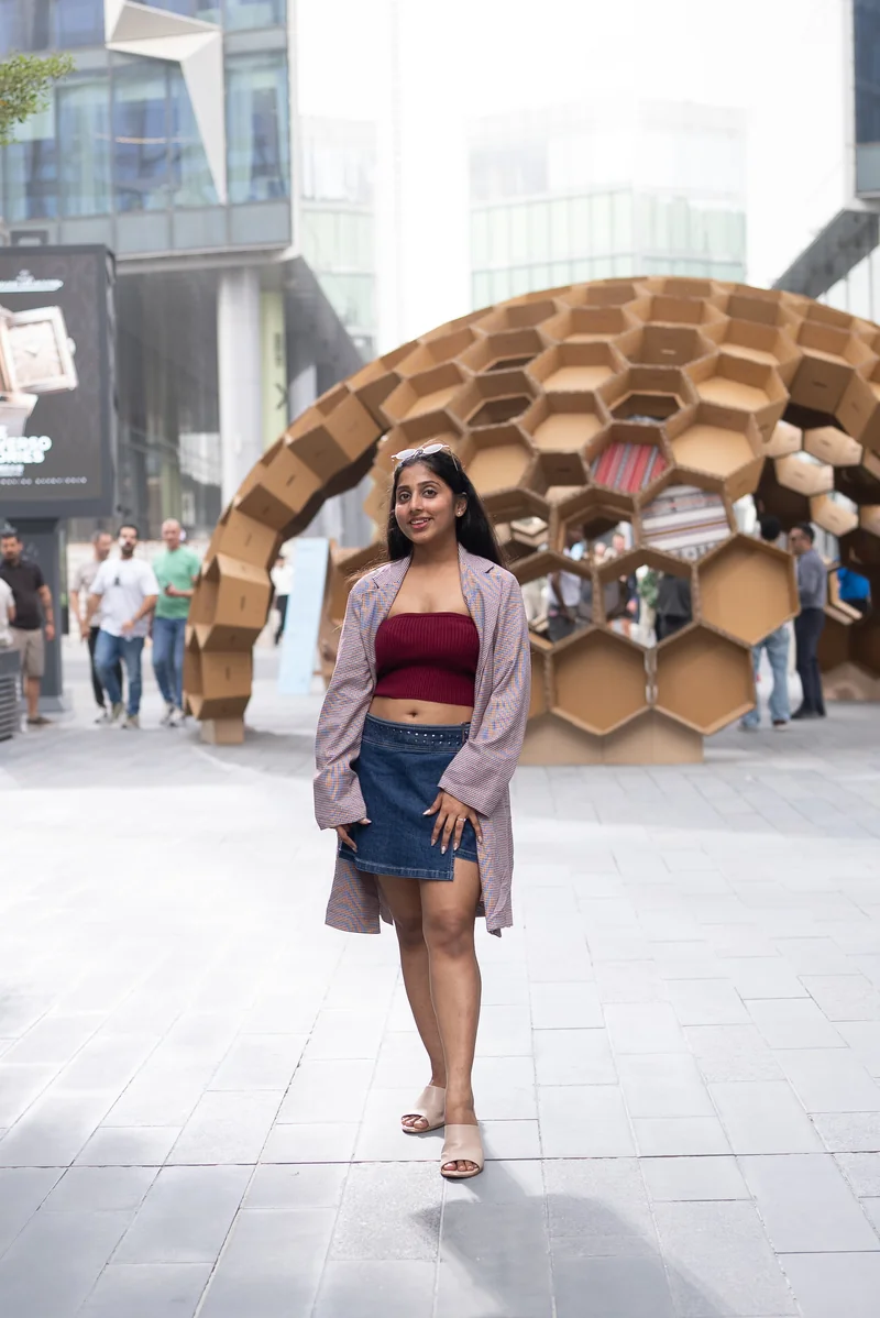 A Design Safari participant in front of a honeycomb pavilion at Dubai Design Week 2025
